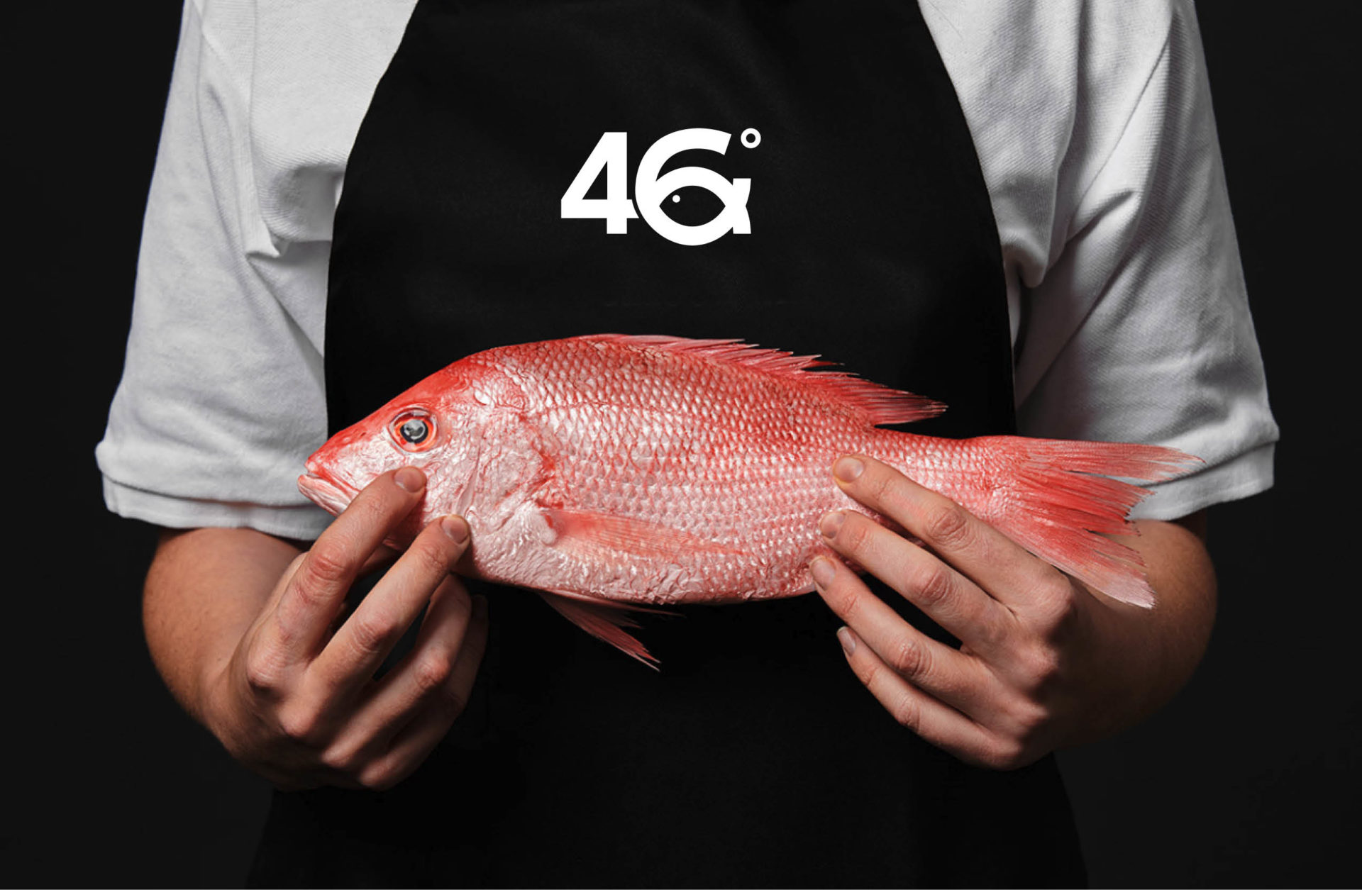 Person with 46 south apron holding red fish